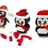 A colorful block construction kit featuring three penguin figures in Santa hats, showcasing various interchangeable pieces and accessories for customization.