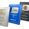 Three customizable award plaques in silver, blue, and black finishes, featuring engraved text and logos for recognition and milestone celebrations.